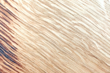 A light background of wood scorched on the edge. Texture, diagonal, soft wavy lines. High quality photo