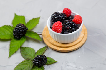 Ripe sweet blackberry on gray concrete background.