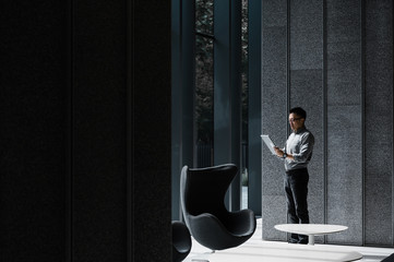Businessman using laptop in office lobby