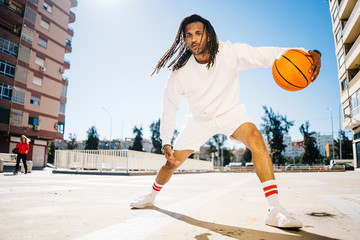 Sportsman playing basketball on street court