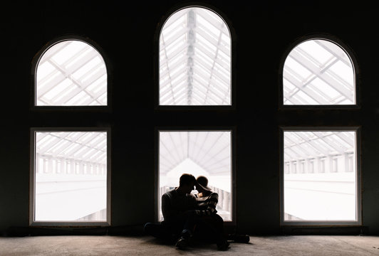 couple in love sitting on the floor in front of panoramic window