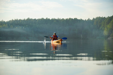 The guy is kayaking on the lake in the fog © Serhii Prystupa