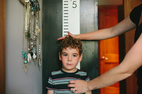 mom measures boy on growth chart