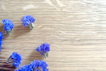 blue dry flowers on a light wooden background. High quality photo