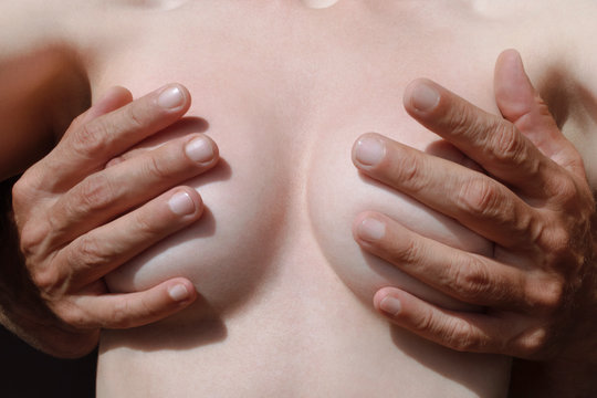 female breasts in male hands closeup