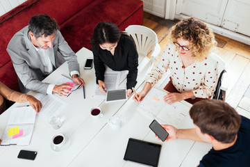 Business people using gadgets in cafe