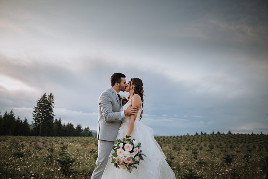 Bride and Groom Kissing in Beautiful Landscape