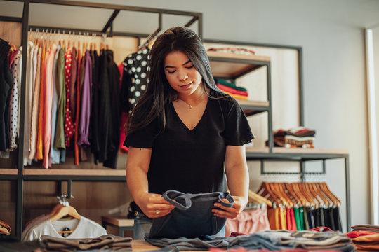 Latin woman owner of small business. Entrepreneurial woman working in her clothing store.