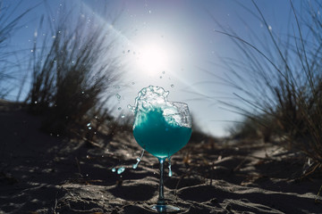 Bebida azul vertida en copa de balon en la playa © MiguelAngelJunquera