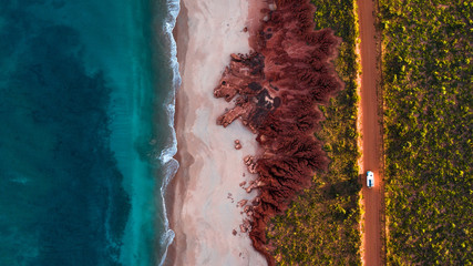 camping truck on rugged coastline from above
