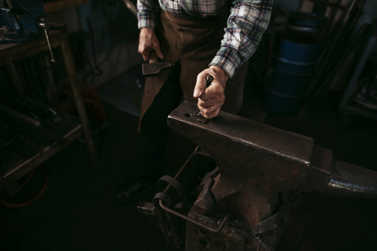 Mature man working in blacksmith shop.