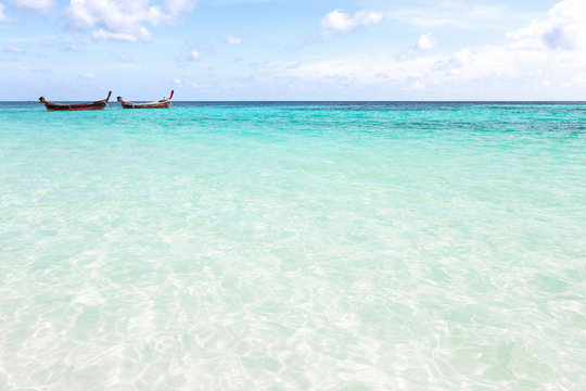 Two long tail boats in tropical sea