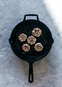 Garlic cloves with rosemary in cast iron