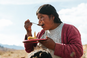 Hispanic woman in the Andes eating