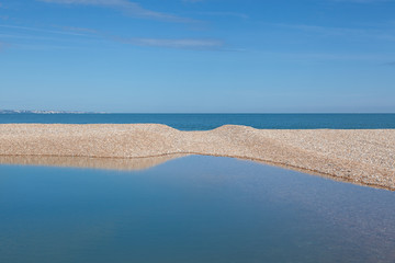 Pool of water on Dungeness beach; one of the largest shingle beaches in Europe.
