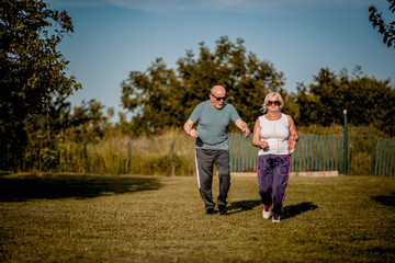 Senior couple running outside . Elderly man and  woman jogging together.