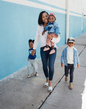 Family wearing blue coordinating outfits walking on sidewalk