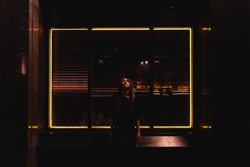 Woman looking up with a square of lights behind