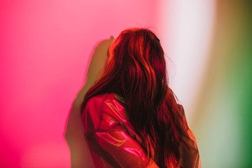Unrecognizable woman under colorful illumination