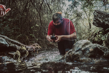 Chico disfrutando de su cámara en el río 