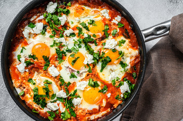 Breakfast with Fried eggs, tomatoes. Shakshuka in pan. Turkish  traditional dishes. Gray background. Top view