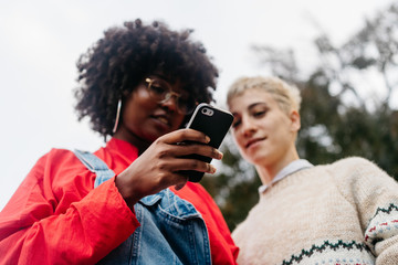 Two women at street with smartphone