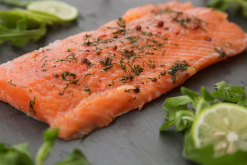 a piece of lightly salted salmon on a black background close up.