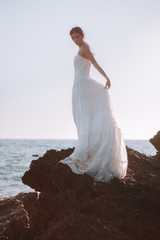 Fototapeta na wymiar Novia en la playa con el traje de boda