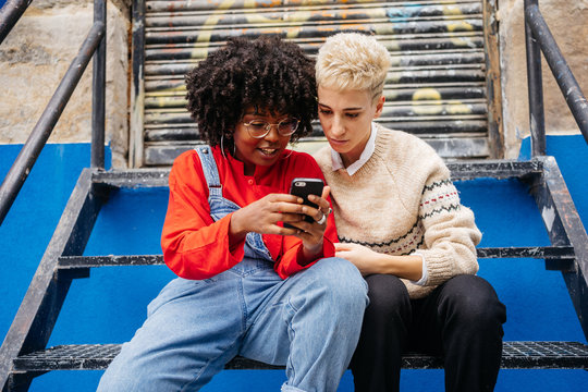 Two women at street with smartphone
