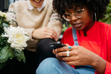 Two women at street with smartphone