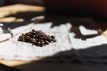 Granos de cafe a la luz del sol sobre un trapo beige