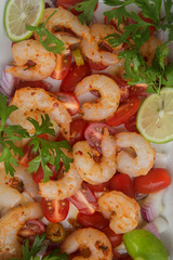 fresh raw peeled prawns with sliced cherry tomatoes, herbs and spices.