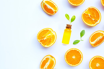 Orange essential oil with fresh fruits on white background.