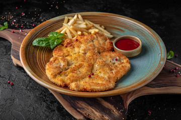 Large Viennese chicken schnitzel with potatoes.