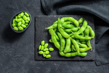Raw Green edamame soybeans. Black background. Top view