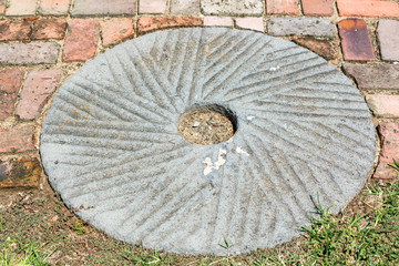 Millstone set in brick and grass