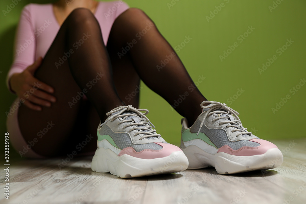 Wall mural beautiful sports sneakers on women's legs. beautiful female legs wearing sport shoes