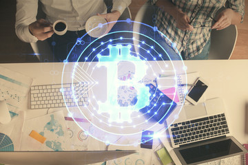 Double exposure of man and woman working together and crypto theme hologram drawing. Computer background. Blockchain concept. Top View.