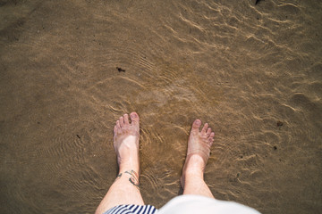 Pies en el agua de la playa