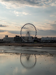 Seaside town landscape during low tide, with Ferris wheel 