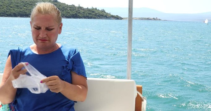 Middle aged woman having a nausea sea sickness during the boat trip