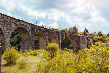 Fototapeta na wymiar Viaduct railway bridge in Vorokhta. Ancient architecture landmark. Trip to Carpathian mountains in Ukraine