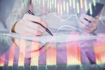 Double exposure of forex chart sketch hologram and woman holding and using a mobile device. Financial market concept.