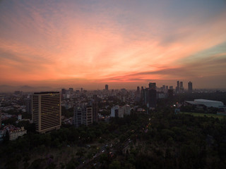 Fototapeta na wymiar Espectacular amanecer en la Ciudad de México, con cielo rojo y el skyline de Polanco como fondo.