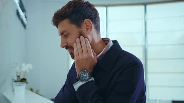 Attractive businessman in suit stand feel pain in tooth problem sadness sick stress toothache touch unwell close up slow motion