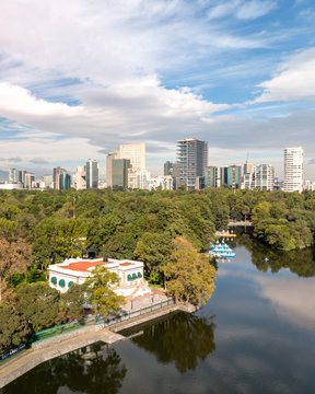 A&eacute;rea sobre el Lago de Chapultepec con vista al skyline de Polanco con un espectacular cielo azul y nublado. Recorte vertical.