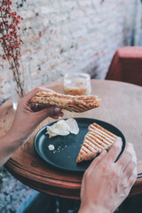 Woman eating grill sandwich ham cheese and salad ( lettuce, ham, cheese, tomato and potato chip)with a cup of coffee for Breakfast meal in morning.