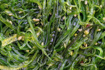 The seaweed salad with sesame seeds and red pepper in background. Top view, © OlegD