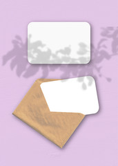 An envelope with two sheets of textured white paper on the pink background of the table. Mockup...