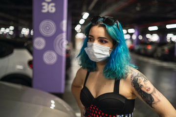Chica alternativa con el pelo azul y tatuajes posando